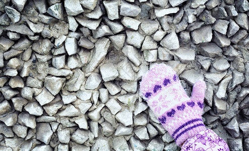 孩子们手握温暖的冬季针织紫色手套图片