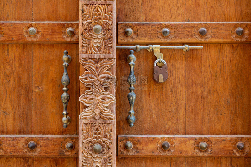 阿曼AlMudairib老城棕色木制门雕刻和金图片