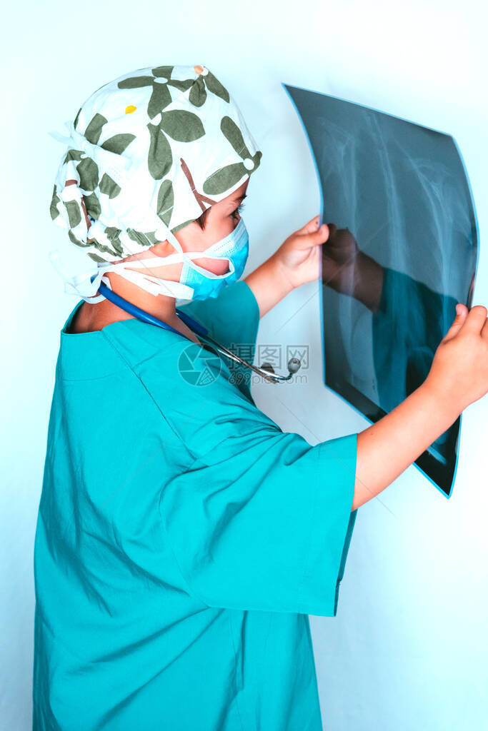 可爱的孩子扮演医生打扮成检查X光片的外科医生图片