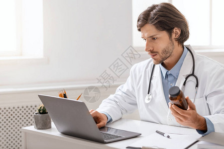 年轻医生在办公室用笔记本电脑空间上看图片