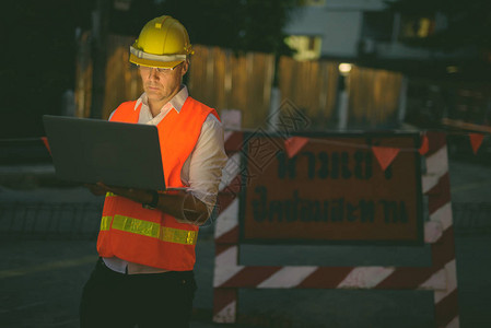 夜间城市建筑工地成熟男建筑工人画像图片
