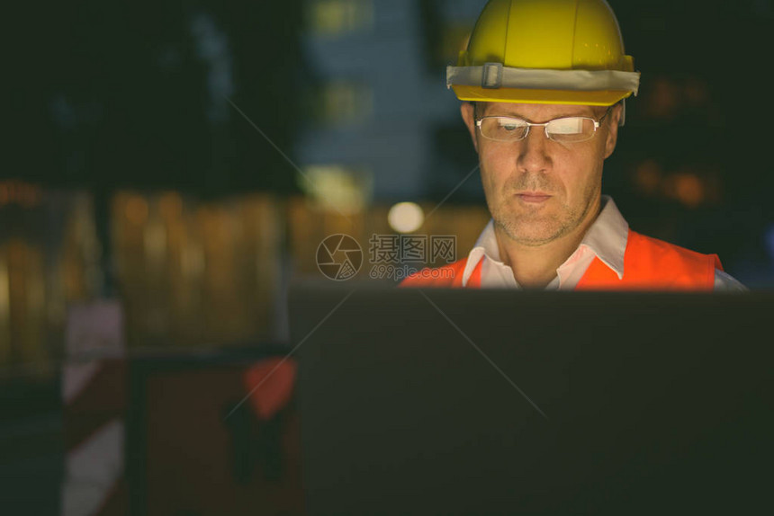 夜间城市建筑工地成熟男建筑工人画像图片