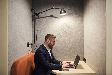 使用笔记本电脑在办公室咖啡间复印空间打工时享受工作的笑胡子商图片