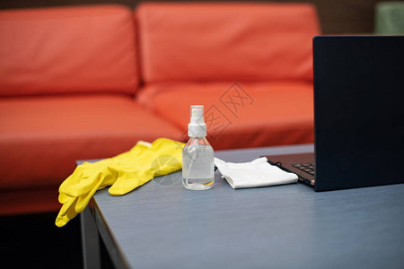 防冠状的个人防护设备医疗面具消毒剂和手套放在桌上的笔记本电脑附图片