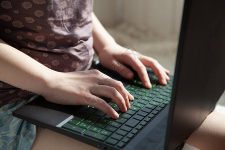 一个穿着家居服的女孩在家里用笔记本电脑工作隔离期间在家远程工图片