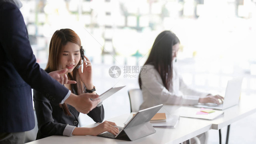 女客户服务在呼叫中心操作室提供信息时使用耳图片