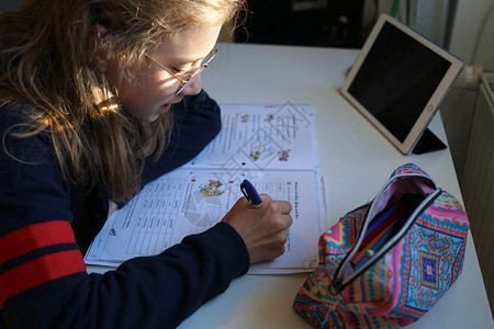 真正10岁的金发女学生带眼镜在做家庭教学在家图片