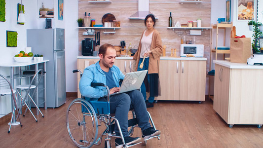 坐在轮椅上的残疾企业家在笔记本电脑上工作图片