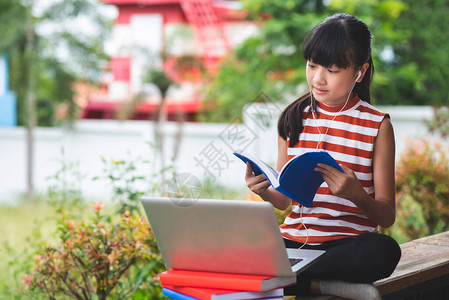 亚洲的小学生在离家很远的地方坐学在线教育概念图片