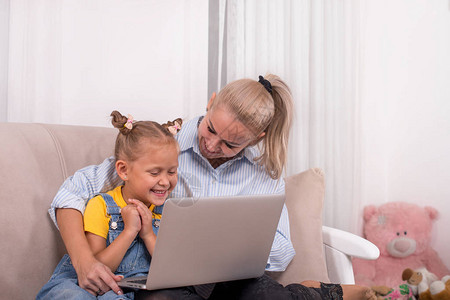 一位母亲和她的小女儿在家里用笔记本电脑进行视频通话的镜头他们图片