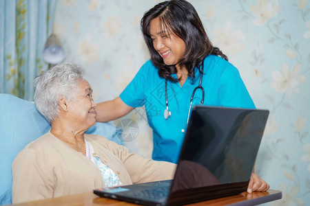 亚洲老年或老年妇人患者使用笔记本电脑图片