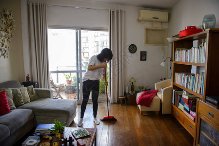 打扫公寓房间的中年妇女图片