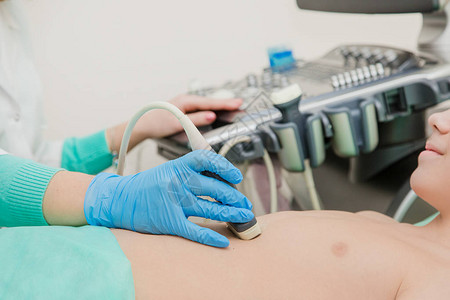 女医生使用超声波扫描仪检查病人的胃部青少图片