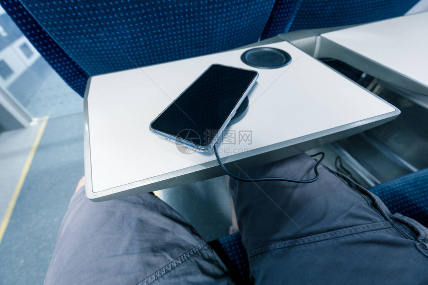 乘火车旅行时用无线充电器给手机充电图片