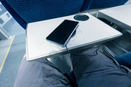 乘火车旅行时用无线充电器给手机充电图片