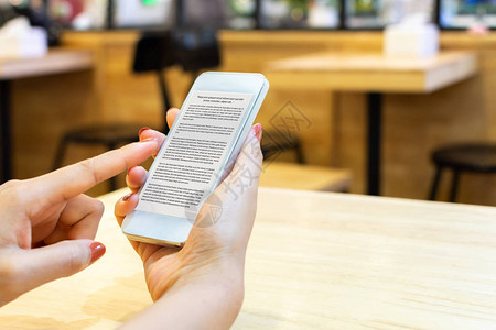 妇女使用应程序移动设备在线数字智能手机阅读电子书和电图片