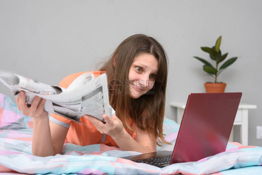 一个女孩手里拿着报纸的女孩躺在床上图片