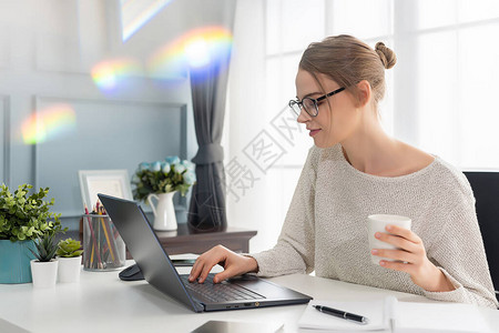 美丽的女人在家里用笔记本电脑工作图片