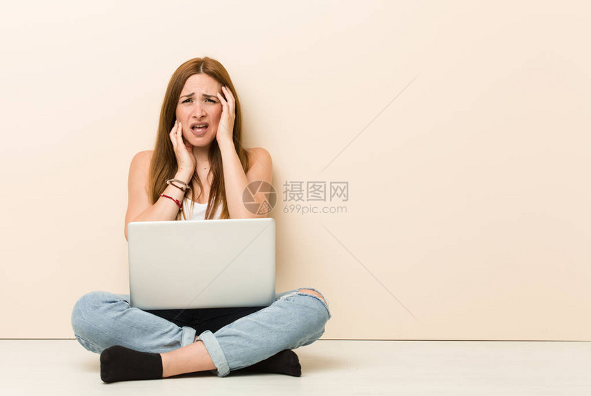 年轻的姜女人坐在她家的地板上哭泣和图片