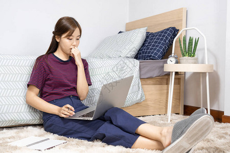 亚洲休闲商务女在卧室的笔记本电脑上远程工作在线课程教育图片