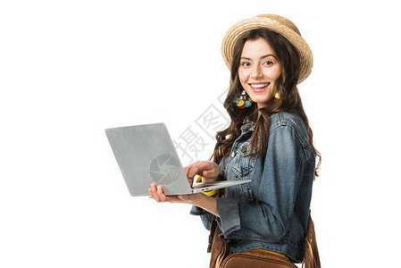 坐在船上的快乐的boho女孩拿着笔记本电脑在图片