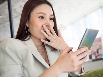 漂亮的女企业家老板正在玩手机情感和反应惊喜图片