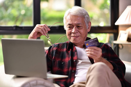 使用信卡在线购物的亚洲快乐老人Appy图片