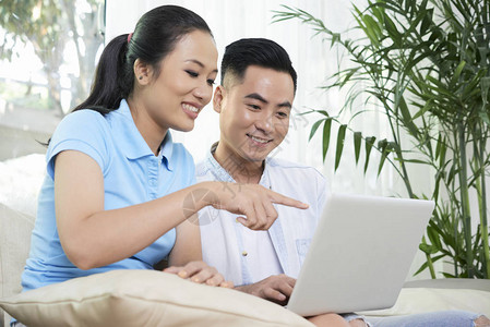 利用平板电脑在网上为员工订购新公寓的越南年轻夫妇点餐图片