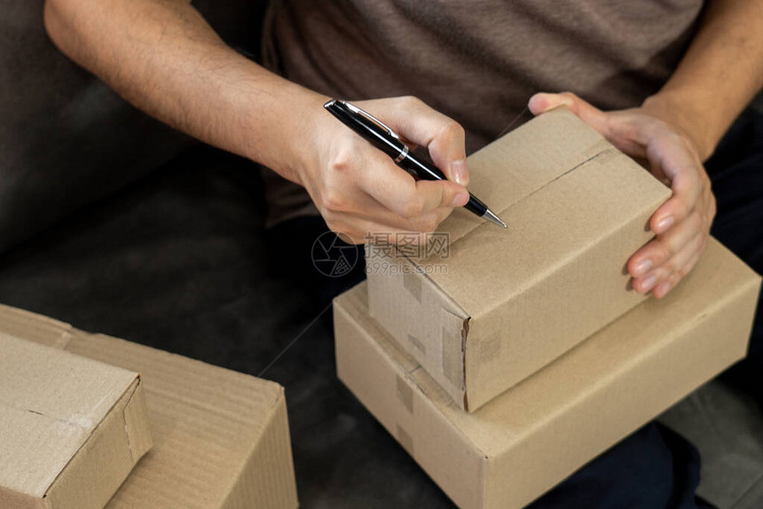 配送业务中小型企业SME工人包装箱在配送仓库的家庭办公室中图片