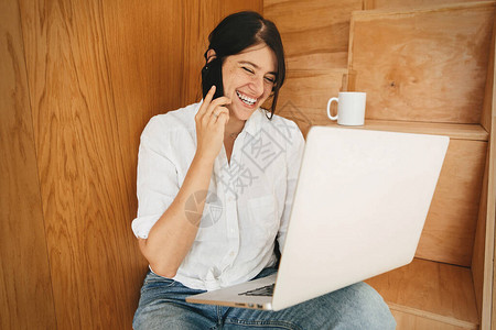 年轻的休闲女在网上购物或在家线工作并面带微笑图片