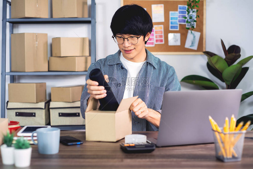 亚洲男企业家小企业家SME自由职业者在家办公室使用盒子到在线营销包装和交付场景图片