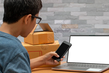 亚洲男子使用智能手机从客户那里检查在线购物订单图片