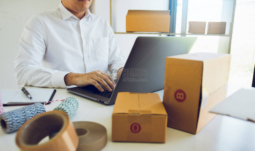 企业家正致力于通过在办公室的键盘笔记本电脑上键入信息来接受客图片