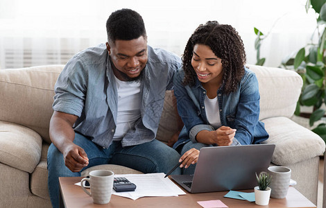 年轻的非洲配偶在家一起管理家庭预算图片