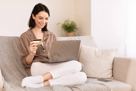 快乐女孩利用笔记本电脑和信用卡在互联网上购物图片