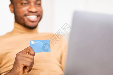 使用信卡和笔记本电脑在门内网上购买非洲快乐的美国男子客户图片