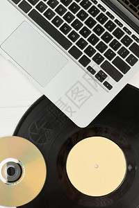 笔记本电脑黑胶唱片和光盘银色笔记本乙烯基LP唱片和DVD光盘图片
