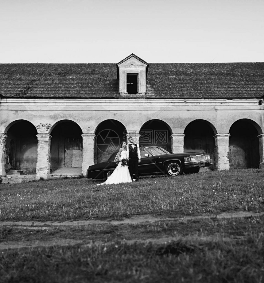 在旧楼附近结了婚夫妇新娘和新郎在旧车旁图片
