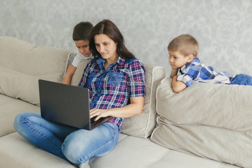 妈和她的孩子们在笔记本电脑上观看视频会议家庭工作社会距离的概念隔离图片