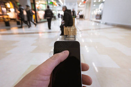 男手持智能手机在购物中心用手机图片