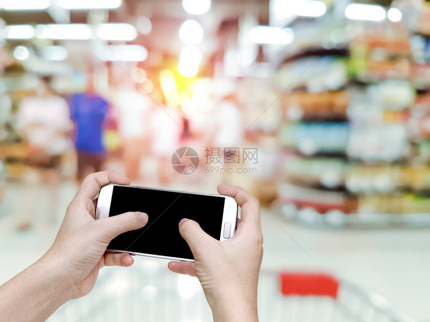 手持移动智能手机在超市背景图片