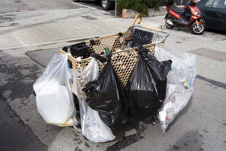 无家可归的人购物车装满了几袋塑料袋图片