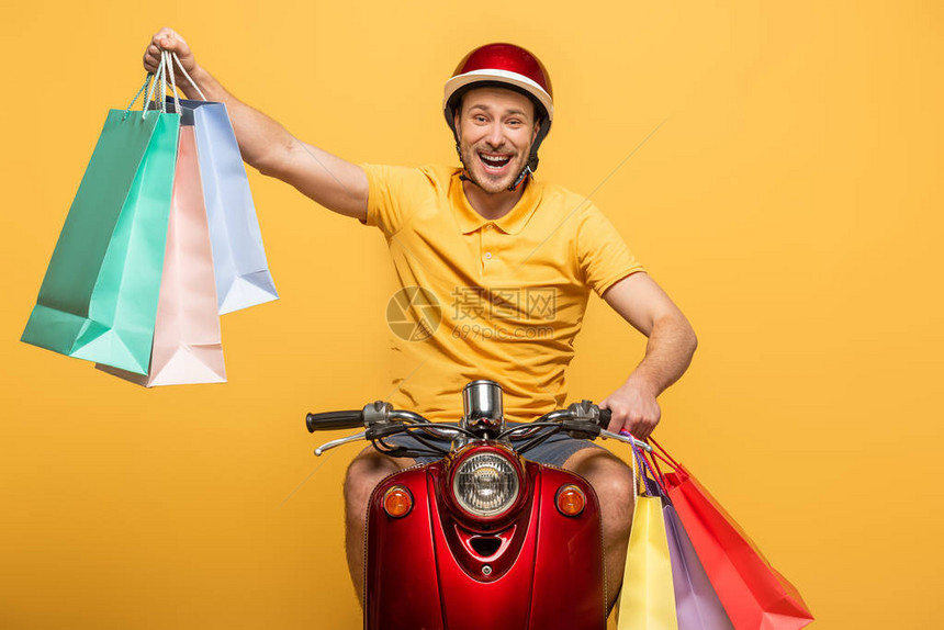 穿着黄色制服的快乐送货员骑摩托车购物图片