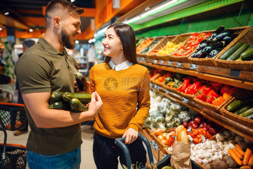 幸福的夫妇一起在杂货店里提着篮子男人和女人在市场上买水果和蔬图片