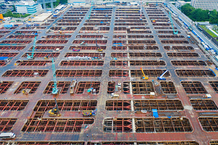 繁忙的工业建筑工地人与起重机和挖掘机一起工作的鸟瞰图图片