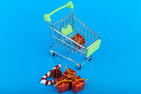 圣诞礼物购概念篮子和圣诞饰品带礼物的圣诞篮网上购物在蓝色背景上图片