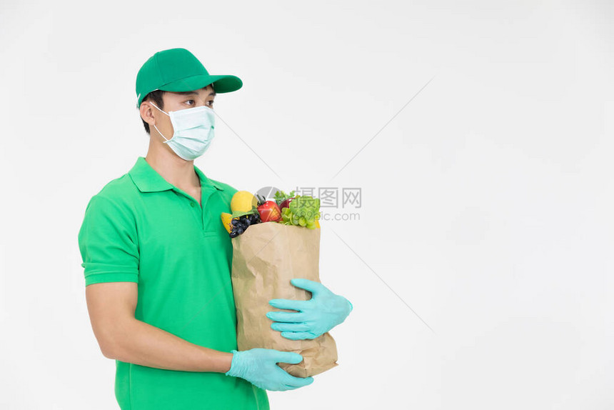 身穿绿色制服头戴面罩的智能送餐服务人员将新鲜食物递给收件人图片