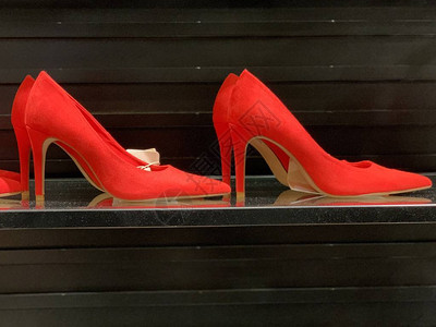 经典优雅的女士高跟鞋在鞋店的深色背景上明亮的女鞋架子图片