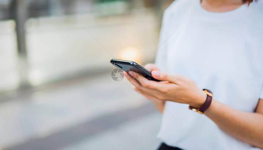 使用黑色智能手机的女人手使用手机的概念在日常生活中图片