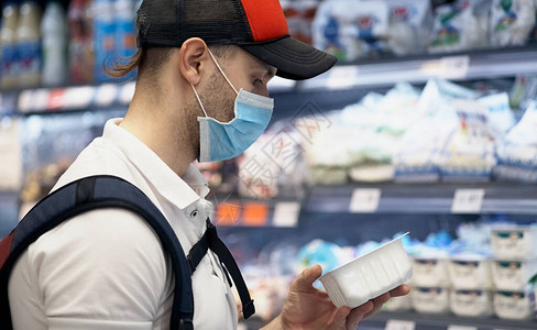 一名戴医疗面具的人在超市周围走来去在公共场所提供个人保护设图片